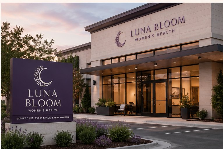 The Luna Bloom Women's Health building at dusk, with a monument sign reading Expert care, every stage, every woman
